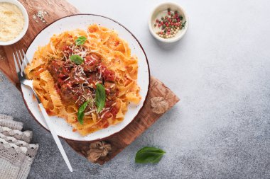 Domates soslu Tagliatelle makarnası ve açık gri kayrak, taş ya da beton arka planda kekik soslu. Geleneksel İtalyan yemeği ve mutfağı. Kopyalama alanı olan üst görünüm.