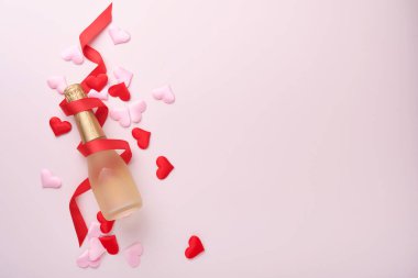 Sevgililer günü tebrik kartı şampanya şişesi, hediye kutusu, kırmızı kurdele ve içinde pembe arka planda boş notlar olan bir zarf. Selamlaşmak için en iyi manzara. Kopyalama alanı olan tebrik kartı