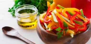 Kereviz, kırmızı ve sarı biber biberli vejetaryen salatası bambu kasesinde arka planda. Üst manzara. Mesaj için yer var. Seçici odak.