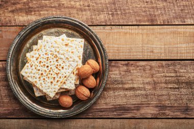 Matzah, kırmızı koşer ve ceviz metal tepsi. Eski ahşap arka planda geleneksel Yahudi ekmeği. Hamursuz Bayramı yemeği. Pesach Yahudi bayramı Fısıh bayramı konsepti.