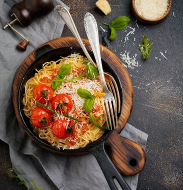 Makarna. Geleneksel İtalyan spagettisi domates soslu ve seramik tabakta parmesan peyniri açık beton arka planda. Seçici odaklanma. Üst görünüm.