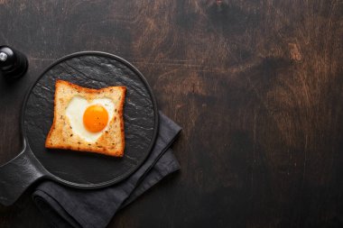 Sevgililer Günü kahvaltısı. Kalp şeklinde kızarmış yumurta ve ekmek ve eski ahşap arka planda taze sebzeler. Sevdikleri için sürpriz kahvaltı. Model.