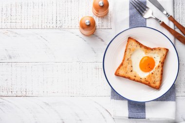 Kalp şeklinde yumurtalı tost ve açık beyaz ahşap arka planda mikro yeşillikler, kahvaltı masası üstü. Sevgililer Günü kahvaltısı. Üst Manzara. Model.