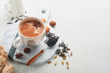 Masala çayı. Masala chai sütlü ve baharatlı çay açık gri arka planda. Geleneksel Hint içkisi. Baharat içeceği. Uzayı kopyala Seçici odak.