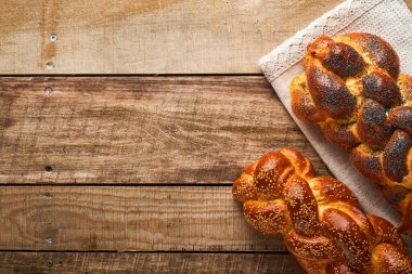 Şabat Şalom. Susam tohumlu ekmek, ahşap arka planda haşhaş tohumu. Geleneksel Yahudi ekmeği Şabat ve Tatil için. Kaba bir kavram. Uzayı kopyala Seçici odak.