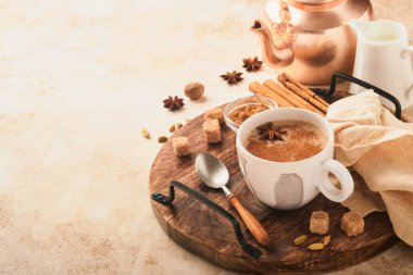 Masala çayı. Masala chai sütlü ve baharatlı sıcak bej arka planda. Geleneksel Hint içkisi. Uzayı kopyala Seçici odak.