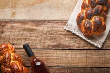 Şabat Şalom. Susam tohumlu ekmek, ahşap arka planda haşhaş tohumu. Geleneksel Yahudi ekmeği Şabat ve Tatil için. Kaba bir kavram. Uzayı kopyala Seçici odak.