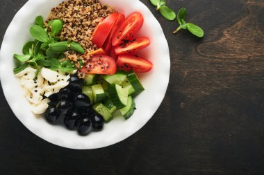 Vejetaryen vejetaryen salata kasesi ya da domates, salatalık, mozzarella peyniri, kinoa, zeytin ve mikroyeşillik ile birlikte Buda kasesi. Sağlıklı ve dengeli gıda kavramı eski ahşap arka plan Üst görünüm kopyalama alanı