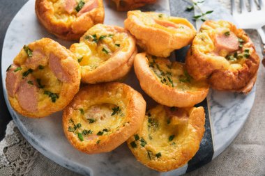 Yeşil soğanlı, pastırmalı, peynirli ve domatesli nefis yumurtalı kekler ahşap ahşap arka planda. Sağlıklı yüksek protein ve düşük karbonhidratlı kahvaltı. Ev yapımı yemek..