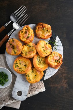 Yeşil soğanlı, pastırmalı, peynirli ve domatesli nefis yumurtalı kekler ahşap ahşap arka planda. Sağlıklı yüksek protein ve düşük karbonhidratlı kahvaltı. Ev yapımı yemek..