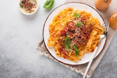 Domates soslu Tagliatelle makarnası ve açık gri kayrak, taş ya da beton arka planda kekik soslu. Geleneksel İtalyan yemeği ve mutfağı. Kopyalama alanı olan üst görünüm.