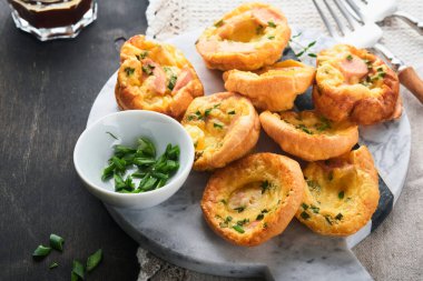 Yeşil soğanlı, pastırmalı, peynirli ve domatesli nefis yumurtalı kekler ahşap ahşap arka planda. Sağlıklı yüksek protein ve düşük karbonhidratlı kahvaltı. Ev yapımı yemek..