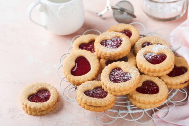 Geleneksel Linzer kurabiyesi, pembe arka planda çilek reçeli ve pudra şekerli. Üst Manzara. Sevgililer Günü 'nde geleneksel ev yapımı Avusturya tatlı yemekleri. Bayram atıştırmalığı konsepti.