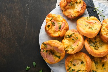 Yeşil soğanlı, pastırmalı, peynirli ve domatesli nefis yumurtalı kekler ahşap ahşap arka planda. Sağlıklı yüksek protein ve düşük karbonhidratlı kahvaltı. Ev yapımı yemek..