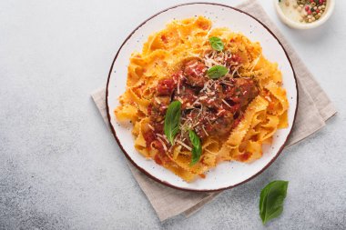 Domates soslu Tagliatelle makarnası ve açık gri kayrak, taş ya da beton arka planda kekik soslu. Geleneksel İtalyan yemeği ve mutfağı. Kopyalama alanı olan üst görünüm.