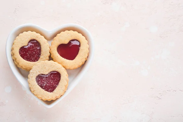 传统的林泽饼干,带有草莓果酱和粉糖粉红漂亮的背景.顶部视图。情人节传统的自制奥地利甜食。假日小吃概念. — 图库照片
