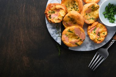 Yeşil soğanlı, pastırmalı, peynirli ve domatesli nefis yumurtalı kekler ahşap ahşap arka planda. Sağlıklı yüksek protein ve düşük karbonhidratlı kahvaltı. Ev yapımı yemek..