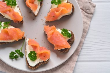 Somonlu mini sandviç, peynirli peynir, maydanoz ve kalp şeklinde çavdar ekmeği. Sevgililer Günü ev yapımı yaratıcı yemekler. Kahvaltı tasarımına bayılırım. Seçici odak ve kopyalama alanı