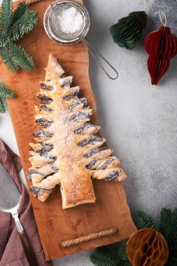 Çikolata ezmeli pudra şekeri serpiştirilmiş Noel ağacı, gri arka planda. Noel ya da Xmas pastaları. Üst Manzara. Boşluğu Kopyala