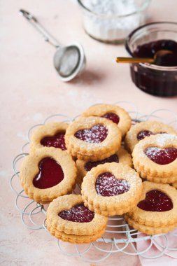 Geleneksel Linzer kurabiyesi, pembe arka planda çilek reçeli ve pudra şekerli. Üst Manzara. Sevgililer Günü 'nde geleneksel ev yapımı Avusturya tatlı yemekleri. Bayram atıştırmalığı konsepti.