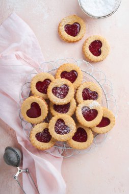 Geleneksel Linzer kurabiyesi, pembe arka planda çilek reçeli ve pudra şekerli. Üst Manzara. Sevgililer Günü 'nde geleneksel ev yapımı Avusturya tatlı yemekleri. Bayram atıştırmalığı konsepti.