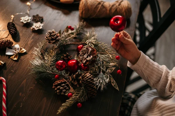 テーブルに座ってクリスマスツリーの花輪を作る白人の子供のクローズアップ — ストック写真