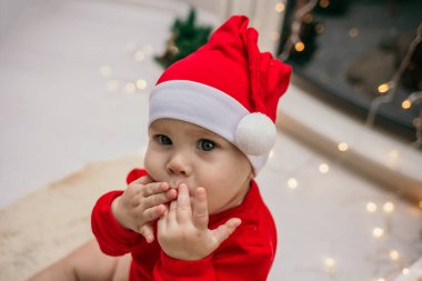 Yeni yıl şapkalı küçük bir bebeğin portresi şöminenin yanındaki odada oturuyor.