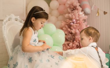 Noel ağacının arka planında yeni yıl erkek ve kız kardeşlerinin portresi.