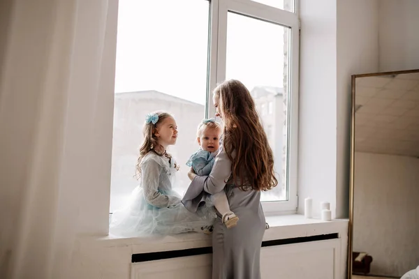鏡を持った部屋の窓辺の窓辺に座って話をしている美しい母親と娘 — ストック写真