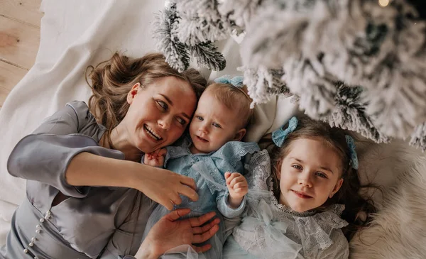 Glad Mamma Och Döttrar Festliga Blå Klänningar Ligger Nära Julgranen — Stockfoto