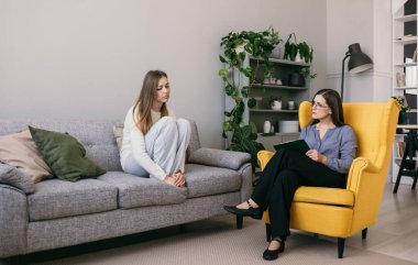 Depresyonda olan bir kadın hasta kanepede oturuyor ve bir psikologa sorunları anlatıyor. Profesyonel psikolojik yardım