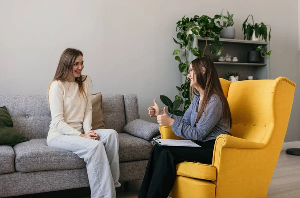 Tatmin olmuş bir kadın hasta psikolog randevusunda kanepede oturuyor. Başarılı psikoterapi kursu