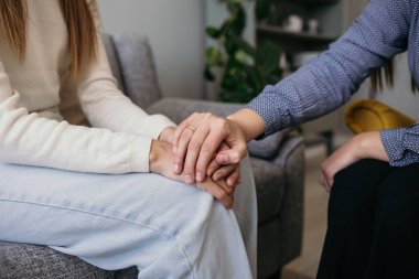 Kadın bir doktor psikoloğu destek için elini tutuyor. Profesyonel psikolojik yardım. Aile içi şiddet