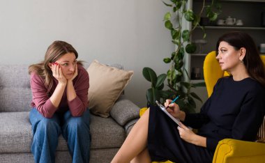 Bir kadın psikolog, sorunlu bir kadın hastaya psikolojik yardım sağlar. Depresyon