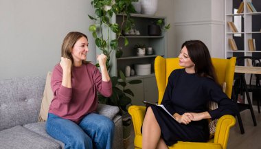 Tatmin olmuş bir kadın hasta psikolog randevusunda kanepede oturuyor. Başarılı psikoterapi kursu