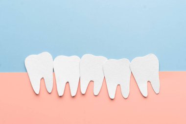 Kalabalık diş karikatürü kağıttan yapılmış. Diş sıkışıklığından kaynaklanan sorunlar arasında sakız hastalığı, çiğneme sorunu, diş ağrısı veya çene ağrısı yer alıyor.