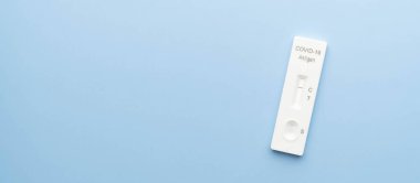 Covid-19 negatif test sonuçları mavi arka planda SARS CoV-2 Hızlı Antijen Test kiti (ATK) olduğunu gösteriyor. Boşluğu kopyala.