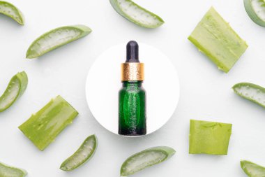 Doğal nemlendirici cilt ürünleri ve yeşil arka planda taze aloe vera. Sağlıklı cilt için cam şişede organik bitkisel özü bulunan serum ya da temel yağlar. Dermatoloji ve tıp konsepti.