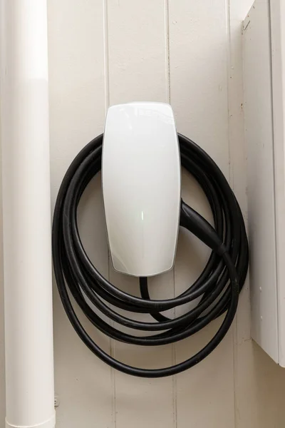 Bir evin duvarında elektrikli araba şarj aleti.