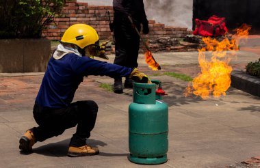 Okuldaki yangın tatbikatı ve acil durum eğitiminde fotokopi alanı var. İtfaiyeciyle birlikte yeşil benzin deposundan çıkan alev..