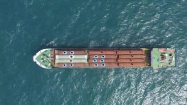 Cargo ship carries industrial metal pipes.