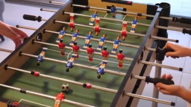 Friends playing together foosball. Hands playing table football. 