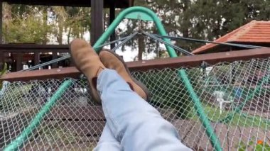 POV lying on a swinging hammock. 