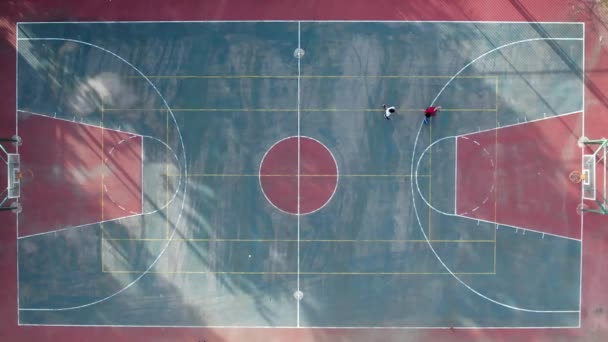 2人の子供がバスケットボールコートで遊ぶ — ストック動画
