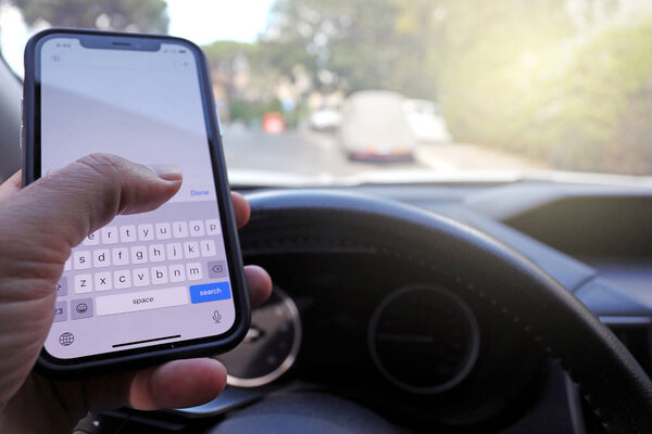 Writing and typing message with cellphone in vehicle. Texting while driving a car. 