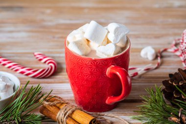 Ahşap arka planda kırmızı bir bardakta marşmelov kokulu kakao. Mutlu Noeller. Sıcak içecekler