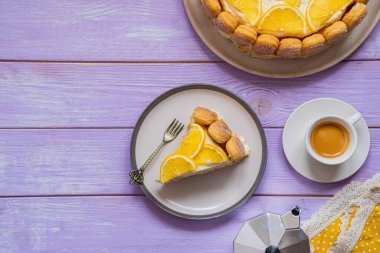 Pişirmeden tatlı, mor ahşap bir zeminde kil tabakta limonla dilimlenmiş Tiramisu keki. İtalyan yemeği. Sevgililer Günü için tatlı, 8 Mart