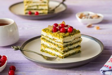 Tatlı, kremalı dilimlenmiş ıspanaklı pasta ya da mor ahşap arka planda seramik tabakta krem peynir kreması. Tatlı tarifleri. İtalyan yemeği.