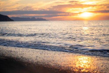Tropik sahilde inanılmaz bir gün doğumu. Denizin üzerinde sarı güneş. Turuncu renk dalgaları. Doğa geçmişi. Güzel sakin bir sahne. - Günaydın. Güneş ışığı su yüzeyine yansıyor