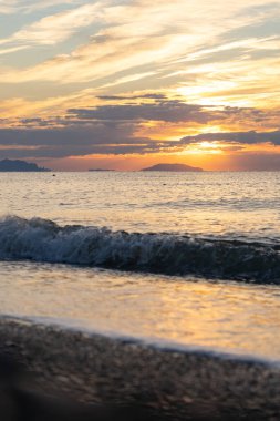 Tropik sahilde inanılmaz bir gün doğumu. Denizin üzerinde sarı güneş. Turuncu renk dalgaları. Doğa geçmişi. Güzel sakin bir sahne. - Günaydın. Güneş ışığı su yüzeyine yansıyor